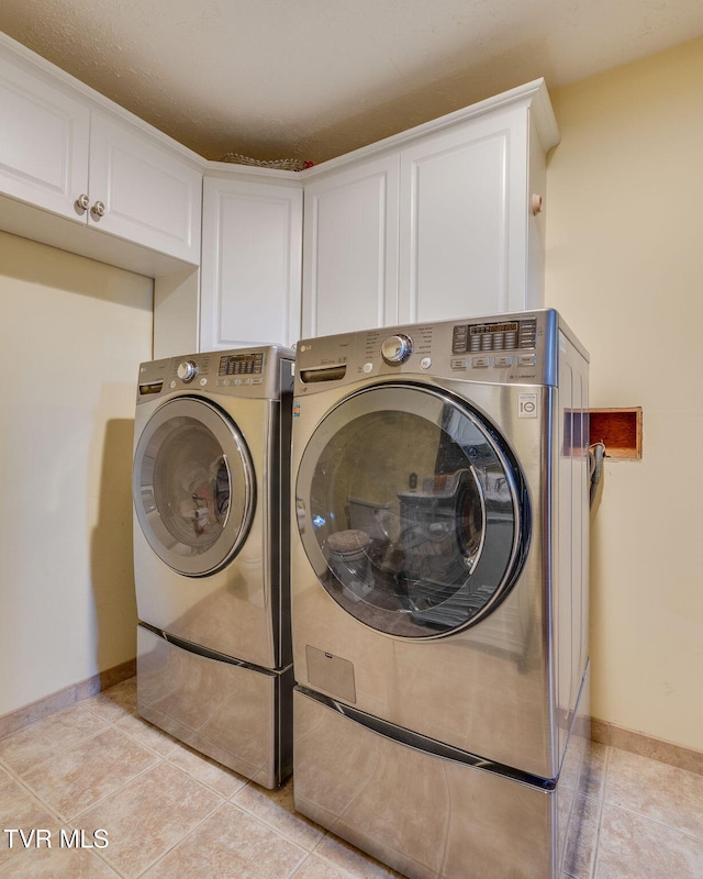 1049 Cooks Valley Rd, Kingsport, TN 37664 - washroom featuring cabinet space, washing machine and dryer, and light tile patterned floors