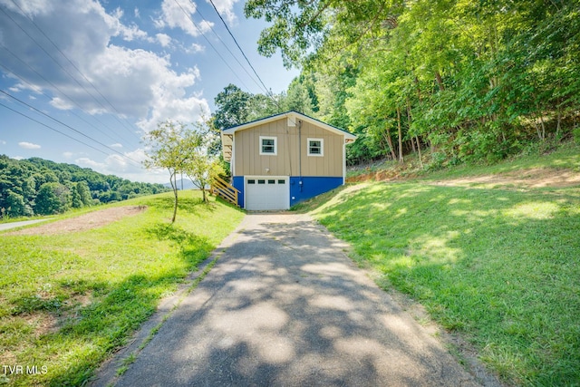 210 Anderson Rd, Johnson City, TN 37601 - view of side of property featuring asphalt driveway, a garage, a lawn, board and batten siding, and a view of trees