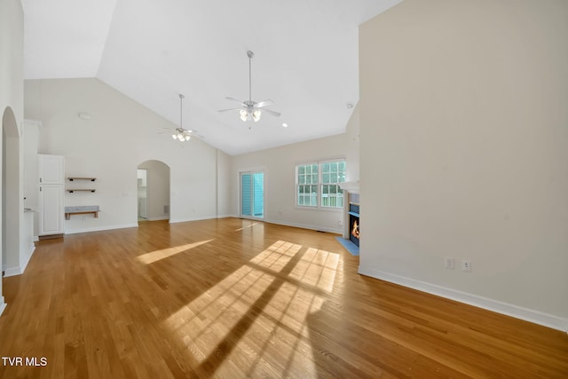 114 Wiltshire Dr, Gray, TN 37615 - unfurnished living room with arched walkways, ceiling fan, high vaulted ceiling, a fireplace with flush hearth, and light wood-type flooring