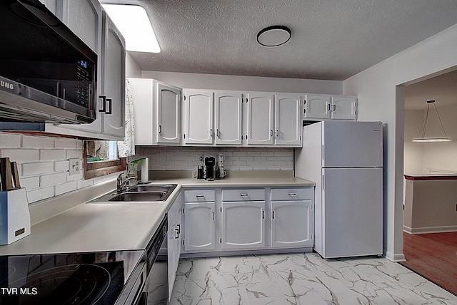220 Tallman Dr, Blountville, TN 37617 - kitchen with freestanding refrigerator, stainless steel microwave, light countertops, decorative backsplash, and black stovetop