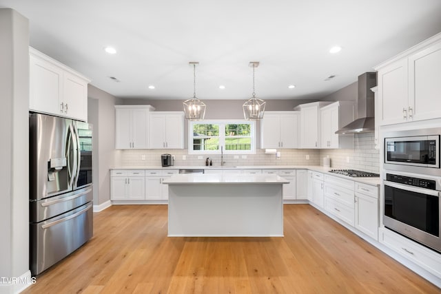 187 Tanners Cv, Johnson City, TN 37615 - kitchen featuring appliances with stainless steel finishes, wall chimney range hood, light countertops, backsplash, and recessed lighting