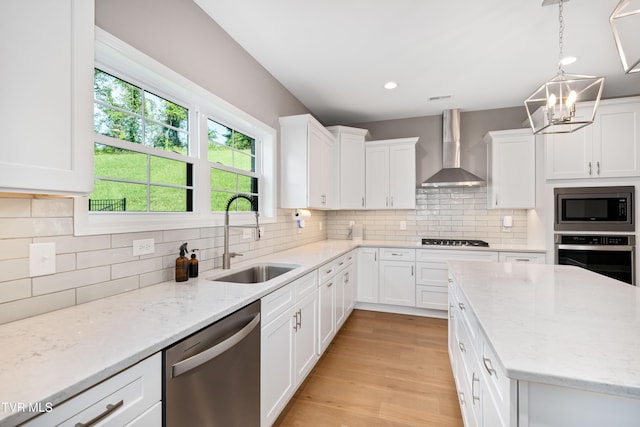 187 Tanners Cv, Johnson City, TN 37615 - kitchen featuring stainless steel appliances, wall chimney range hood, a chandelier, white cabinetry, and tasteful backsplash