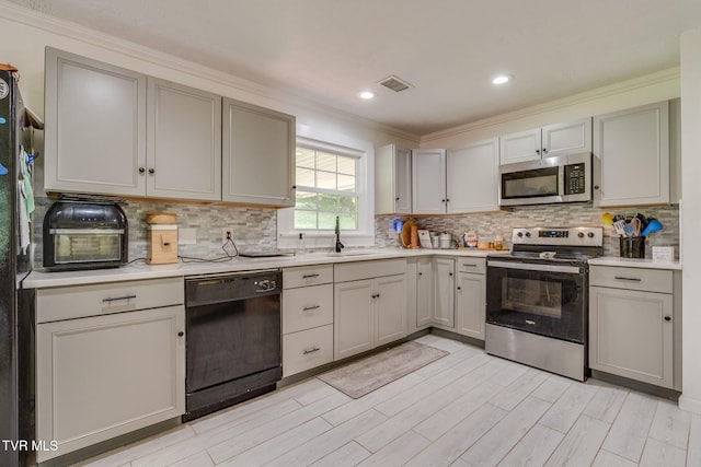 1136 W Shipley Ferry Rd, Kingsport, TN 37663 - kitchen featuring stainless steel appliances, light countertops, crown molding, decorative backsplash, and light wood-type flooring
