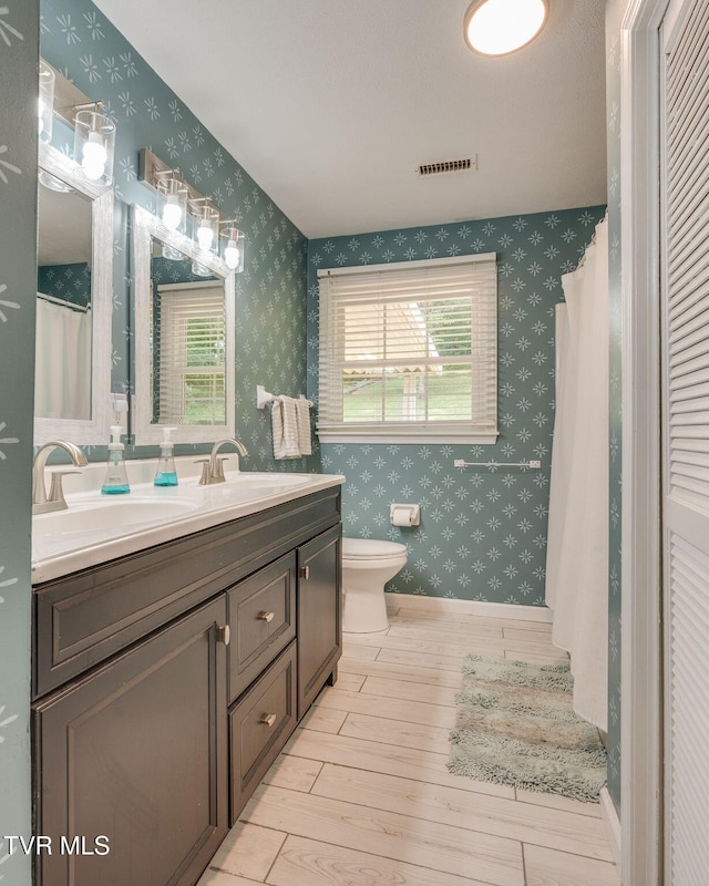 1136 W Shipley Ferry Rd, Kingsport, TN 37663 - full bathroom featuring wallpapered walls, double vanity, and wood finished floors