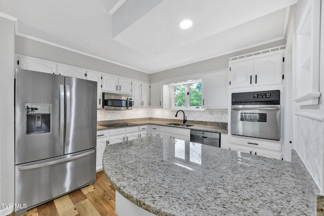 700 Sharon Dr, Johnson City, TN 37604 - kitchen with appliances with stainless steel finishes, light stone counters, white cabinets, crown molding, and light wood-style flooring