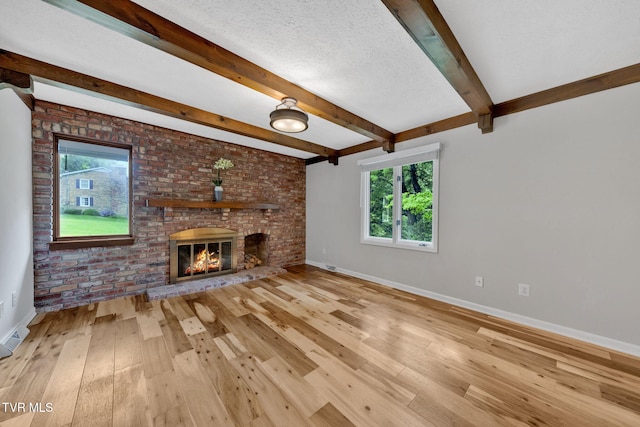 700 Sharon Dr, Johnson City, TN 37604 - unfurnished living room with hardwood / wood-style floors, a fireplace, beamed ceiling, brick wall, and a textured ceiling