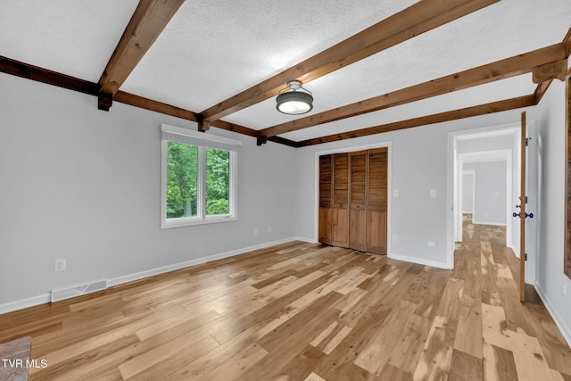 700 Sharon Dr, Johnson City, TN 37604 - unfurnished bedroom featuring light wood-style flooring, beamed ceiling, a closet, and a textured ceiling