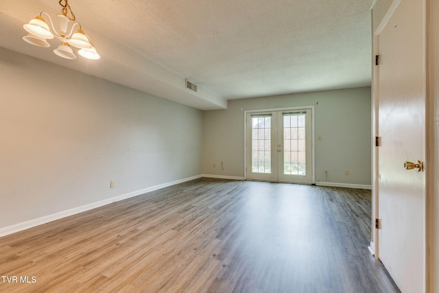 815 7th St Unit 815, Bristol, TN 37620 - spare room with wood finished floors, a textured ceiling, a chandelier, and french doors
