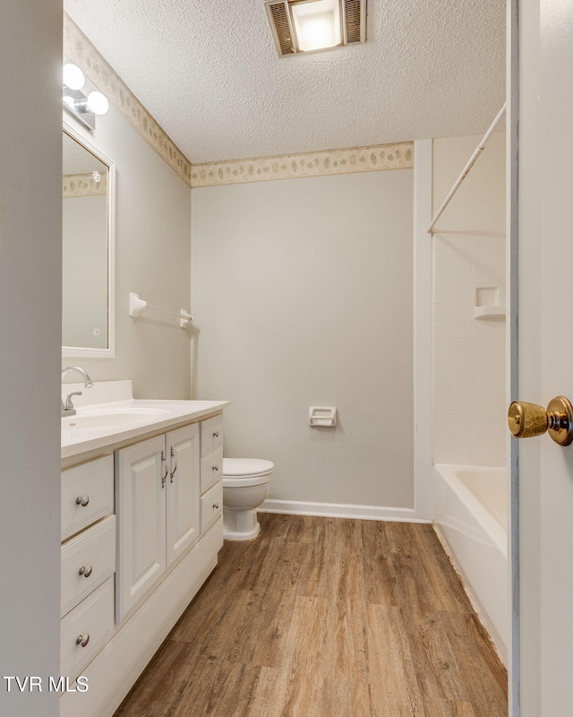 815 7th St Unit 815, Bristol, TN 37620 - bathroom featuring wood finished floors, vanity, a textured ceiling, and shower / washtub combination