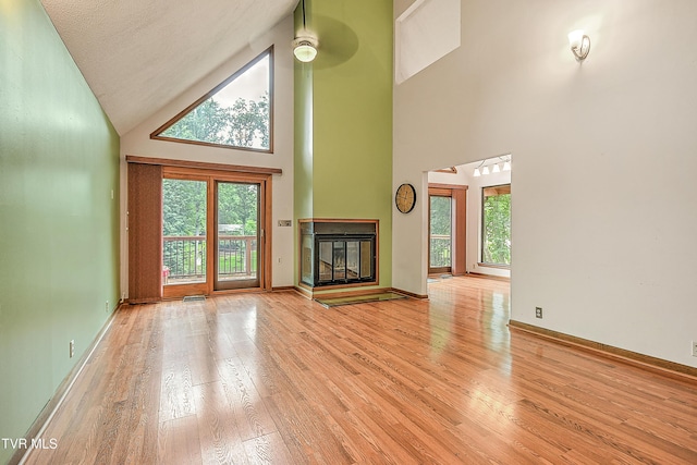 190 Sycamore Cir, Jonesborough, TN 37659 - unfurnished living room featuring high vaulted ceiling, wood finished floors, and a glass covered fireplace
