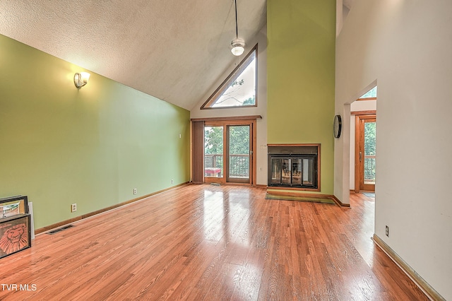 190 Sycamore Cir, Jonesborough, TN 37659 - unfurnished living room featuring high vaulted ceiling, healthy amount of natural light, wood finished floors, a multi sided fireplace, and a textured ceiling