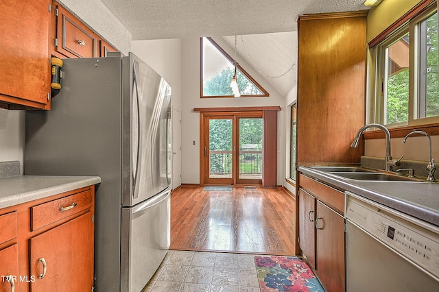 190 Sycamore Cir, Jonesborough, TN 37659 - kitchen with dishwasher, freestanding refrigerator, healthy amount of natural light, brown cabinetry, and lofted ceiling