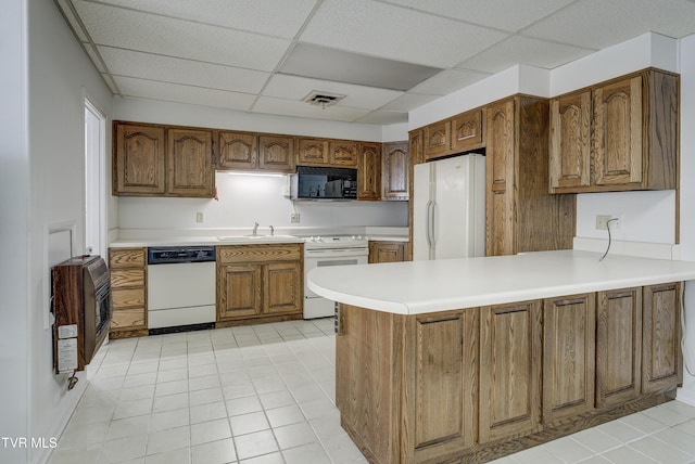 1710 Sundale Rd, Johnson City, TN 37604 - kitchen featuring white appliances, heating unit, a peninsula, a drop ceiling, and brown cabinets