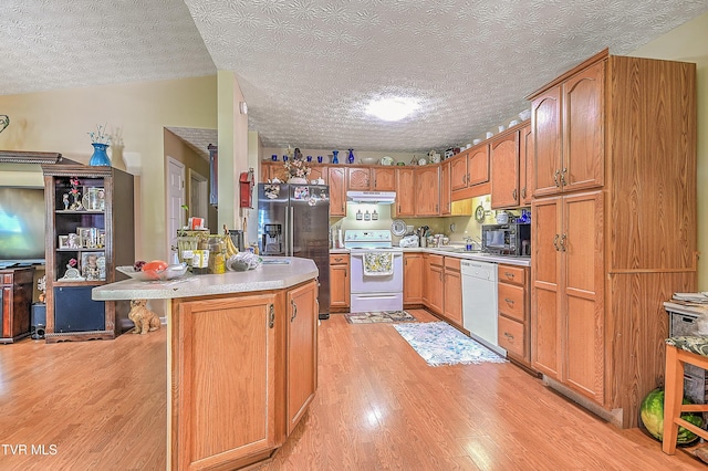 929 Cornerstone Ct, Kingsport, TN 37660 - kitchen featuring white appliances, light wood-style floors, light countertops, a textured ceiling, and under cabinet range hood