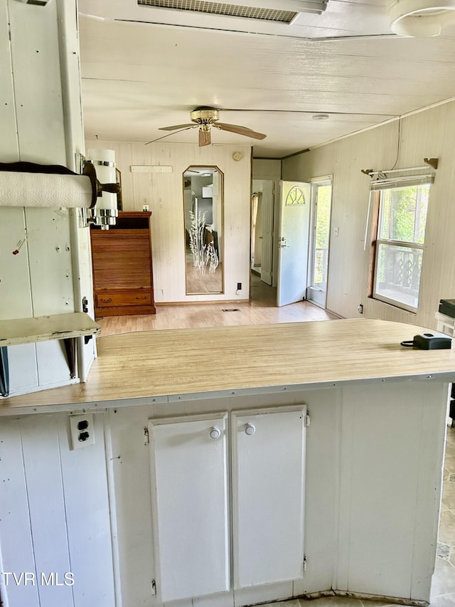 2703 Orr St, Big Stone Gap, VA 24219 - kitchen with a ceiling fan, open floor plan, white cabinets, wooden walls, and light countertops