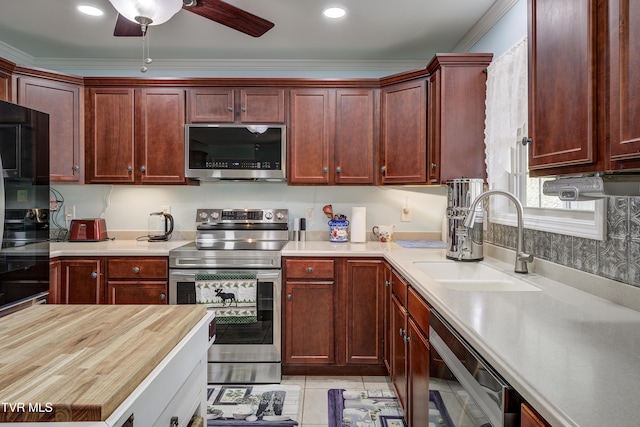 2146 Buttercup Ln, Limestone, TN 37681 - kitchen with appliances with stainless steel finishes, a ceiling fan, reddish brown cabinets, crown molding, and butcher block countertops