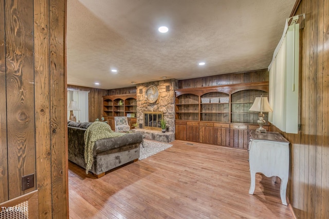224 Meadow Dr, Bristol, TN 37620 - living room with wood walls, a textured ceiling, wood finished floors, a fireplace, and built in features