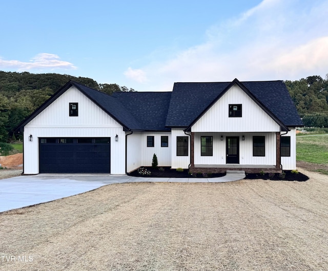 816 Hairetown Rd, Jonesborough, TN 37659 - modern farmhouse featuring concrete driveway, roof with shingles, an attached garage, and a porch
