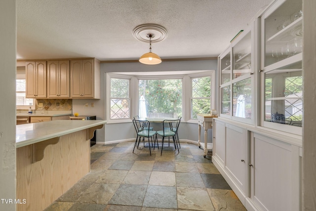 1605 Woodmont Dr, Johnson City, TN 37601 - kitchen featuring stone tile floors, light countertops, a kitchen bar, tasteful backsplash, and hanging light fixtures