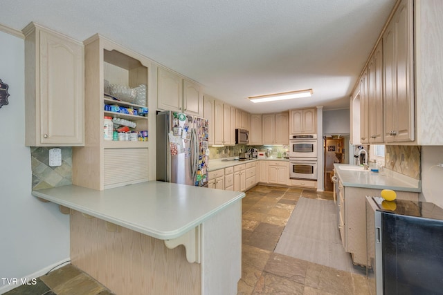 1605 Woodmont Dr, Johnson City, TN 37601 - kitchen with stainless steel appliances, a peninsula, tasteful backsplash, a kitchen breakfast bar, and light countertops