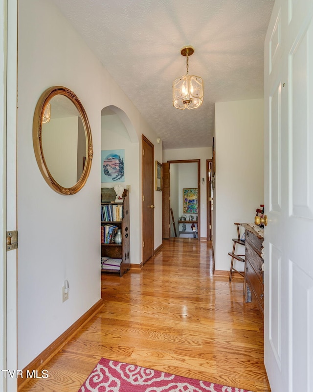 2129 Philon Dr, Kingsport, TN 37660 - hallway featuring a chandelier, light wood-style flooring, and arched walkways