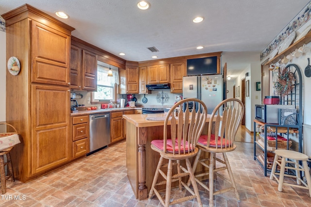 2129 Philon Dr, Kingsport, TN 37660 - kitchen featuring stainless steel appliances, under cabinet range hood, light countertops, brick flooring, and recessed lighting