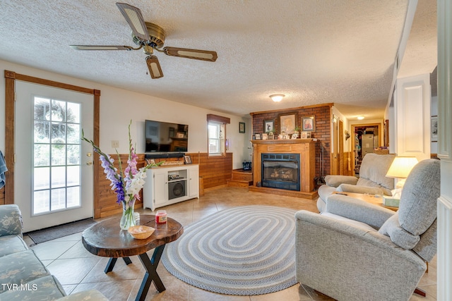 2129 Philon Dr, Kingsport, TN 37660 - living area with a textured ceiling, a large fireplace, light tile patterned floors, a ceiling fan, and a wainscoted wall