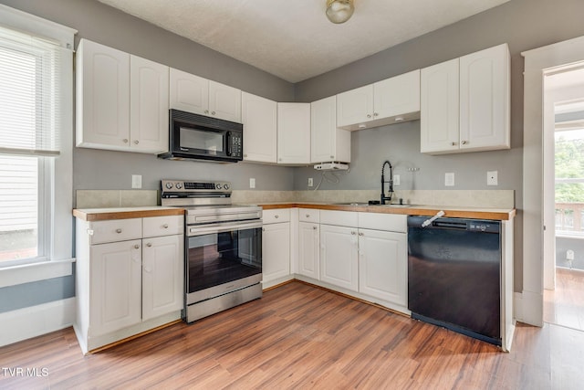 1234 E Center St, Kingsport, TN 37660 - kitchen with black appliances, light wood-type flooring, white cabinetry, and light countertops