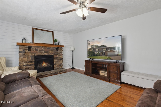 4404 Stillwood Ave, Kingsport, TN 37664 - living area with a textured ceiling, wood finished floors, a ceiling fan, a fireplace, and wooden walls