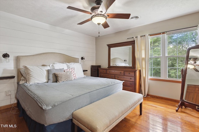 4404 Stillwood Ave, Kingsport, TN 37664 - bedroom with light wood-style floors, wood walls, and ceiling fan