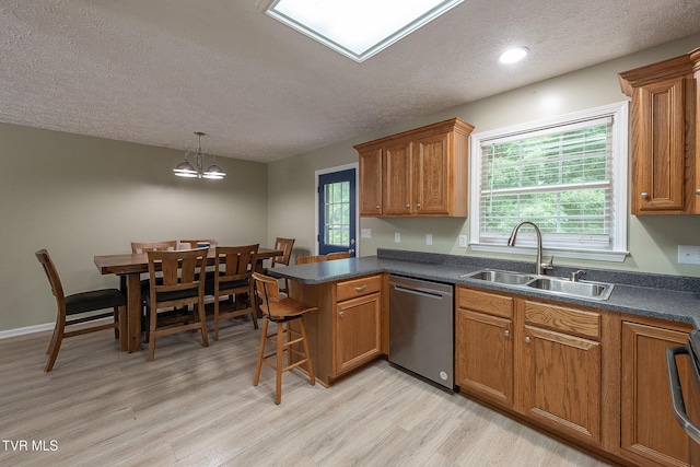 5630 Orebank Rd, Kingsport, TN 37664 - kitchen featuring dishwasher, brown cabinets, a textured ceiling, light wood-style flooring, and dark countertops
