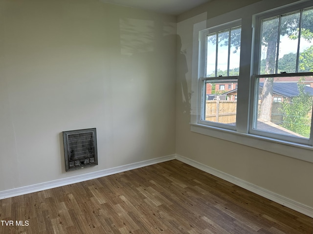 613 Spruce St, Johnson City, TN 37601 - spare room featuring heating unit, wood finished floors, and a fireplace