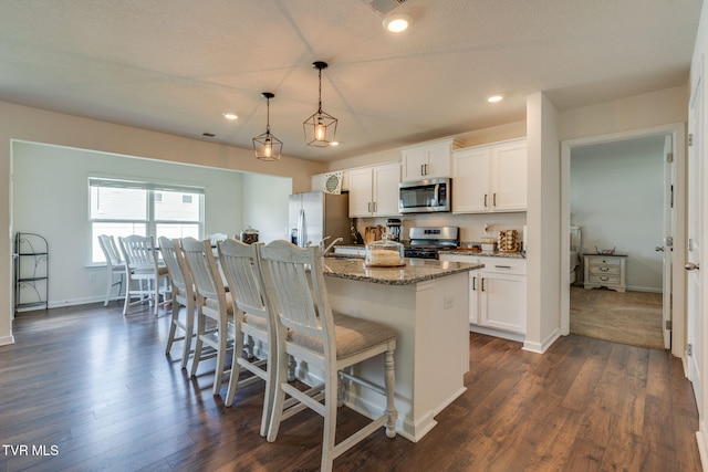 1244 Stamp Lodge Rd, Kingsport, TN 37660 - kitchen with appliances with stainless steel finishes, a breakfast bar area, white cabinetry, light stone counters, and recessed lighting