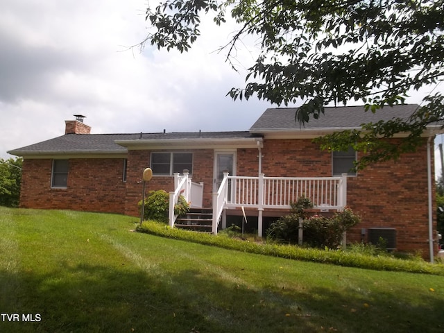 313 Milburn Ave, Kingsport, TN 37660 - back of house with brick siding, a deck, a lawn, and a chimney