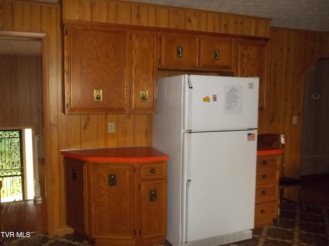 313 Milburn Ave, Kingsport, TN 37660 - kitchen featuring freestanding refrigerator, wooden walls, and brown cabinets