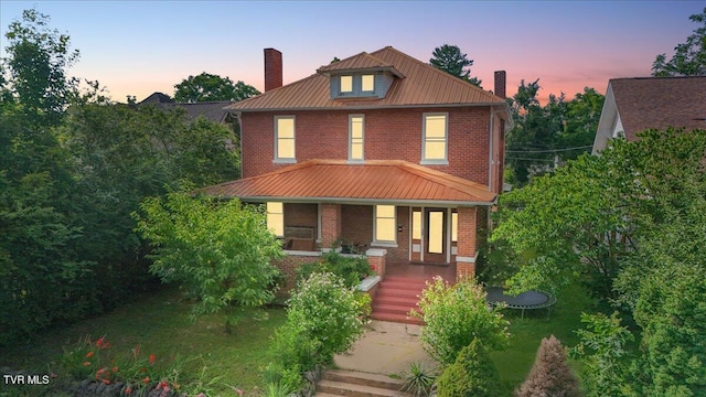 909 Highland Ave, Bristol, VA 24201 - american foursquare style home with a chimney, brick siding, a porch, a metal roof, and a trampoline