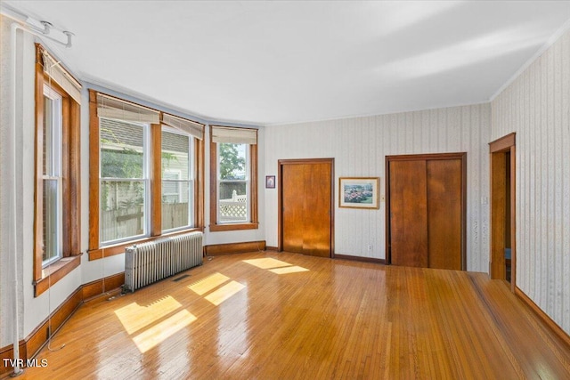 909 Highland Ave, Bristol, VA 24201 - spare room with radiator, wood finished floors, wallpapered walls, and ornamental molding