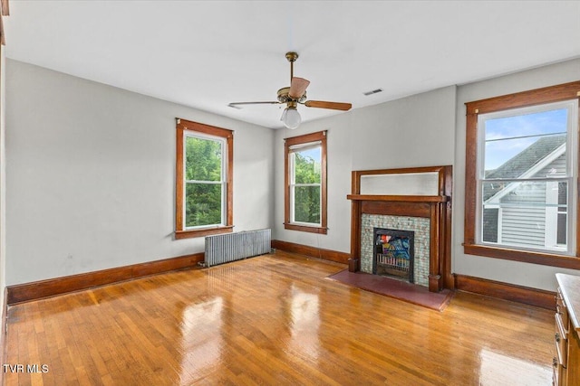909 Highland Ave, Bristol, VA 24201 - unfurnished living room with radiator, wood finished floors, a fireplace, and ceiling fan