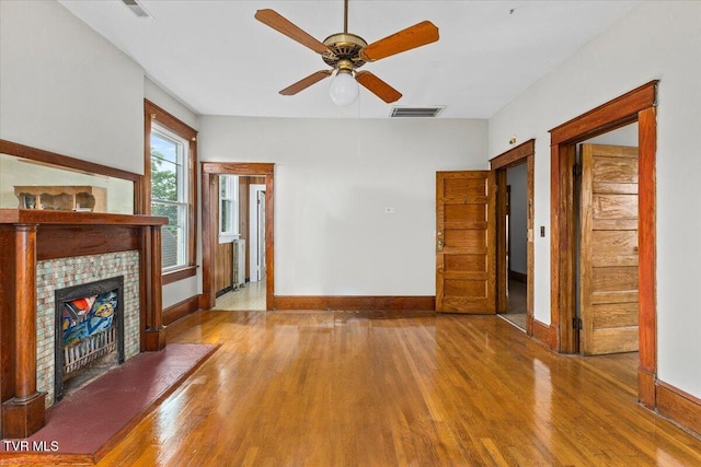 909 Highland Ave, Bristol, VA 24201 - unfurnished living room with wood finished floors, a tiled fireplace, and a ceiling fan