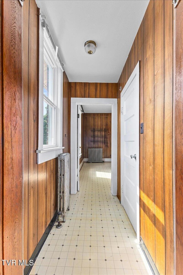 909 Highland Ave, Bristol, VA 24201 - hallway with radiator heating unit, wooden walls, and light floors
