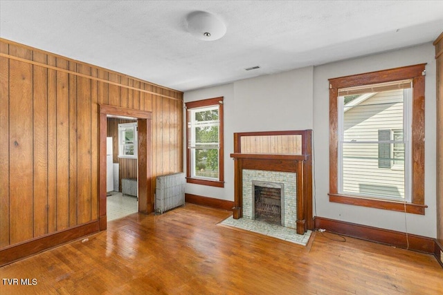 909 Highland Ave, Bristol, VA 24201 - unfurnished living room featuring radiator, wood finished floors, and a fireplace