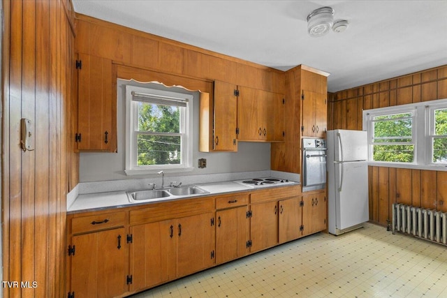 909 Highland Ave, Bristol, VA 24201 - kitchen with white appliances, radiator heating unit, light countertops, brown cabinets, and wooden walls