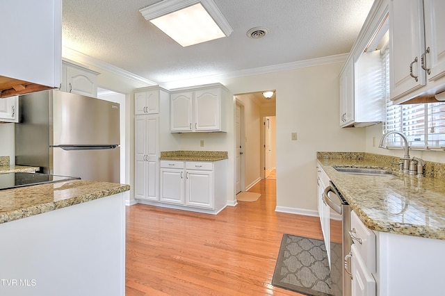 226 Willowbend Ct, Kingsport, TN 37660 - kitchen with appliances with stainless steel finishes, light wood-style flooring, ornamental molding, a textured ceiling, and white cabinets