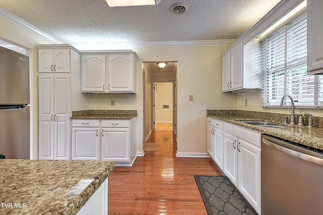 226 Willowbend Ct, Kingsport, TN 37660 - kitchen with appliances with stainless steel finishes, ornamental molding, a textured ceiling, wood finished floors, and dark stone countertops