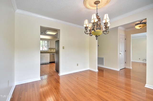 226 Willowbend Ct, Kingsport, TN 37660 - unfurnished room featuring light wood-style flooring, a chandelier, crown molding, and a textured ceiling