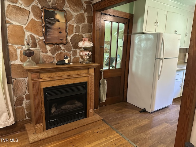 2065 Coeburn Rd, Clintwood, VA 24228 - kitchen featuring freestanding refrigerator, wood finished floors, and a fireplace