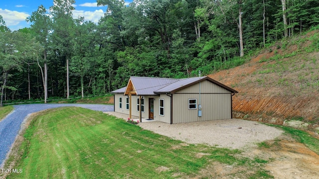 1976 Hartford Rd, Cosby, TN 37722 - view of front of home with gravel driveway, a front yard, a metal roof, and a forest view