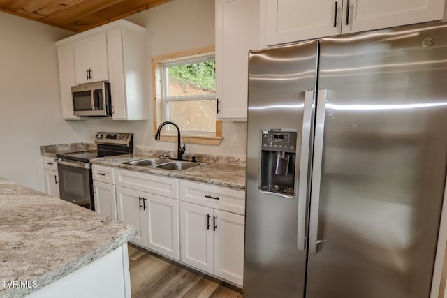 1976 Hartford Rd, Cosby, TN 37722 - kitchen featuring appliances with stainless steel finishes, white cabinetry, wood finished floors, wood ceiling, and light stone countertops