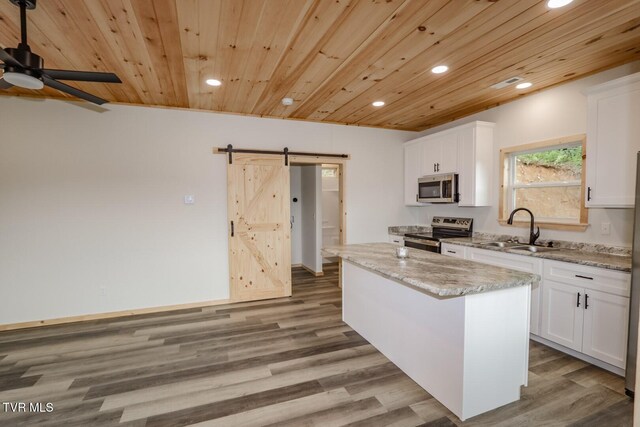1976 Hartford Rd, Cosby, TN 37722 - kitchen featuring stainless steel appliances, a barn door, recessed lighting, wooden ceiling, and white cabinets