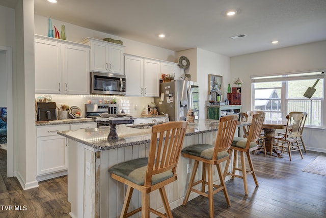 5402 Wildlife Cir, Piney Flats, TN 37686 - kitchen featuring appliances with stainless steel finishes, a center island with sink, dark wood-style floors, white cabinets, and recessed lighting
